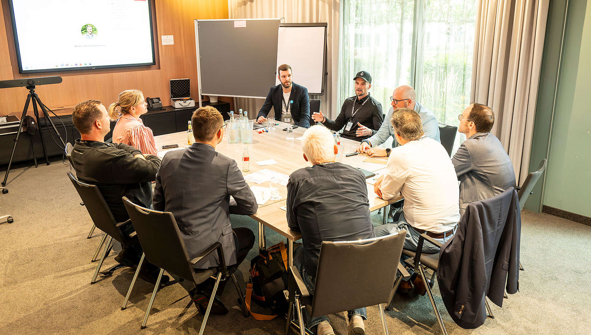 Mehrere Personen sitzen an einem Tisch und führen einen Workshop durch.